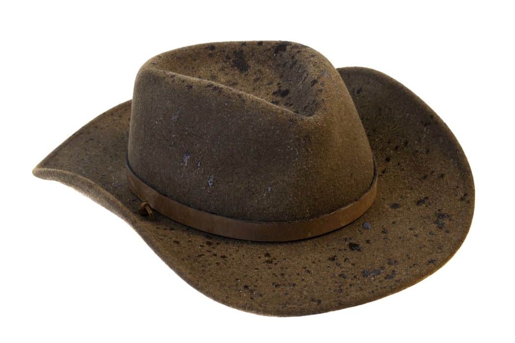 brown wool felt cowboy hat with rain drops isolated on white background