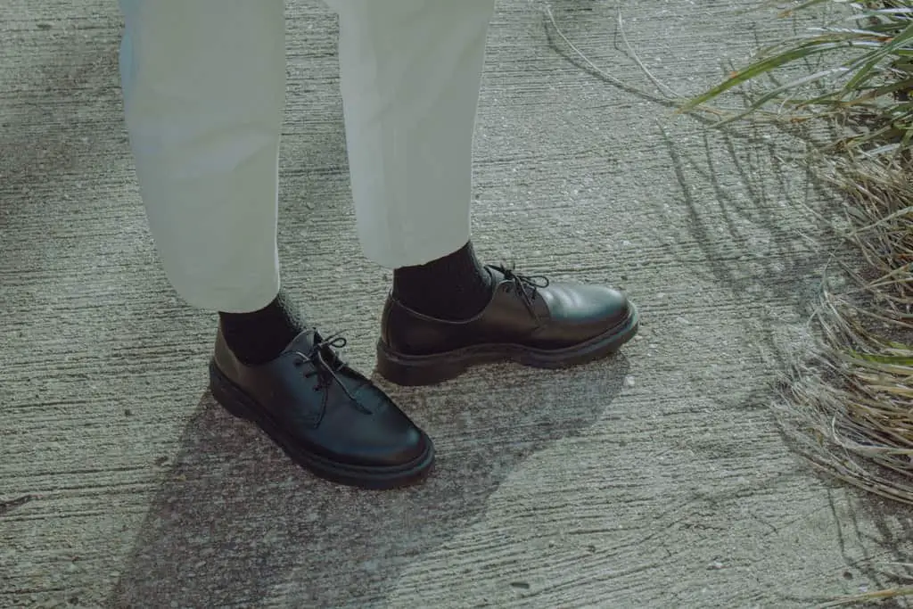 A Person Wearing Black Leather Shoes min